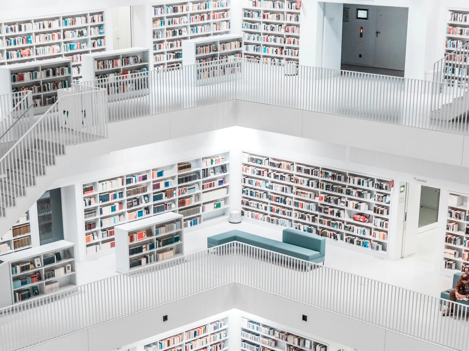 Upper floors of a modern white library, shelves and walkways stacked in tiers