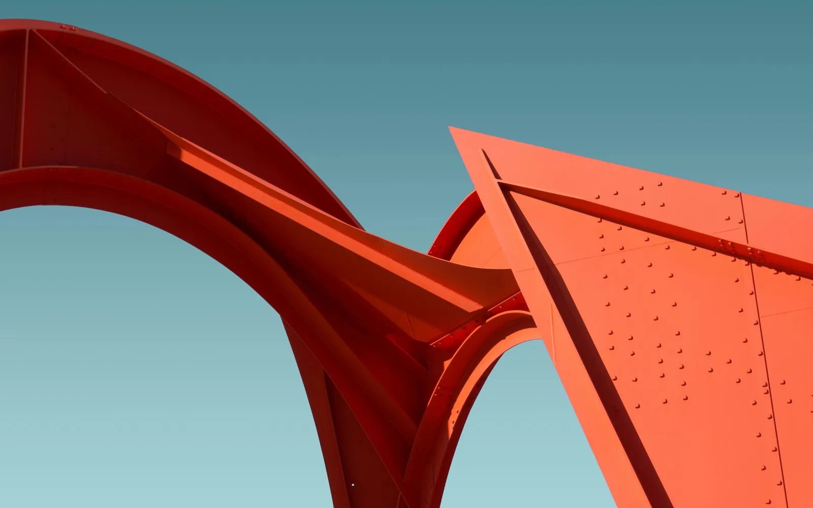 Riveted coral-orange steel arches against a teal sky — the image behind the Stoar brand